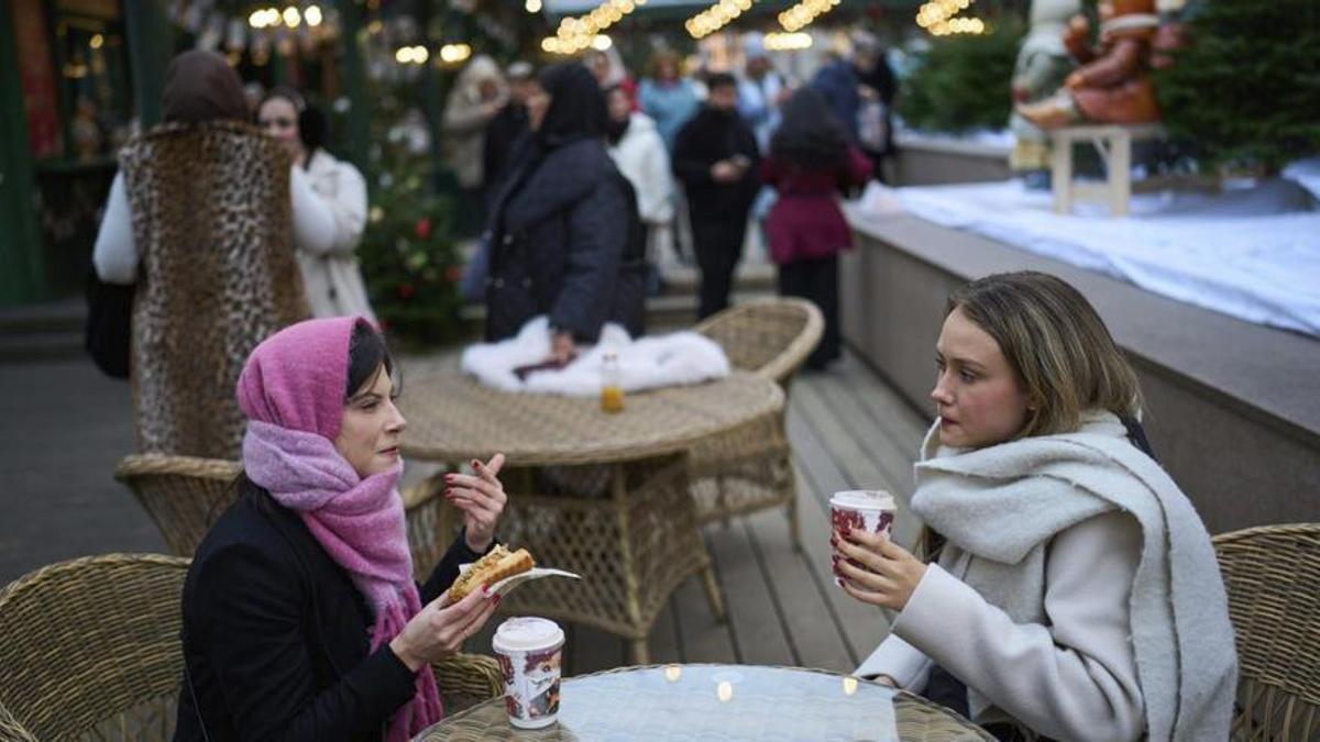 Dos mujeres con café portátil haciendo un alto.