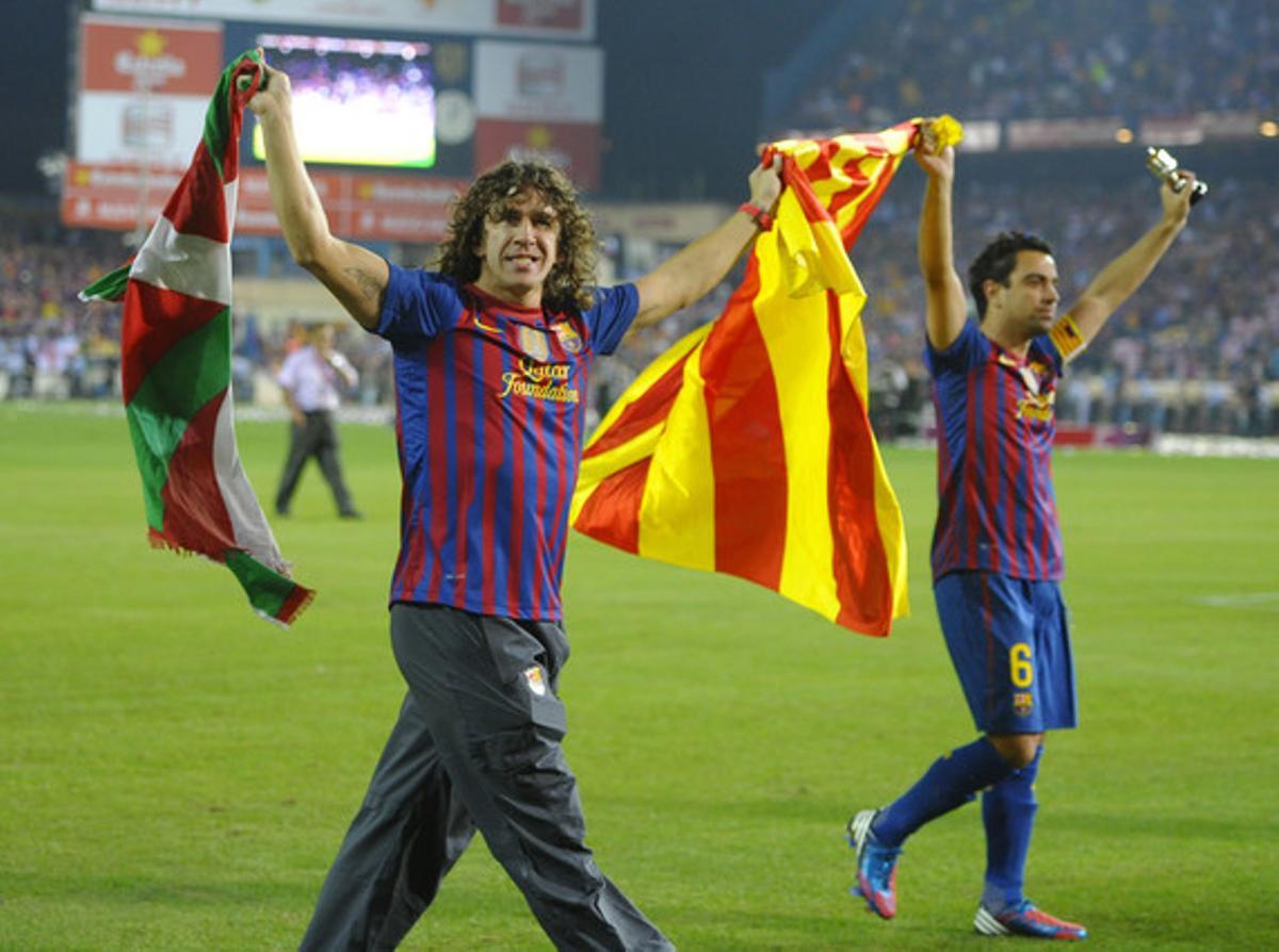 Carles Puyol i Xavi Hernández sostenen la bandera catalana i la del País Basc, després de guanyar la final de la Copa del Rei davant l’Athletic de Bilbao.