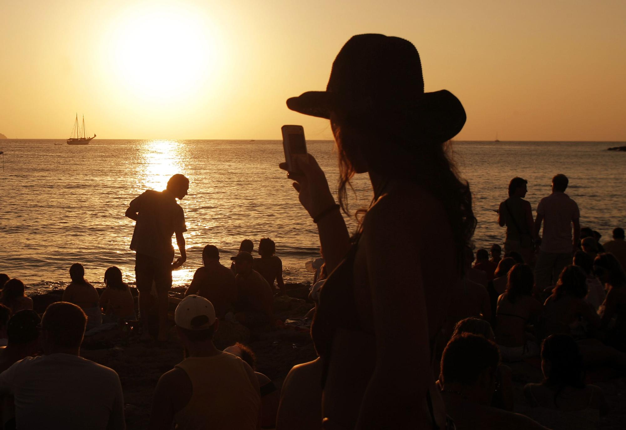 Jovenes durante una puesta de sol veraniega en San Antonio, Ibiza.