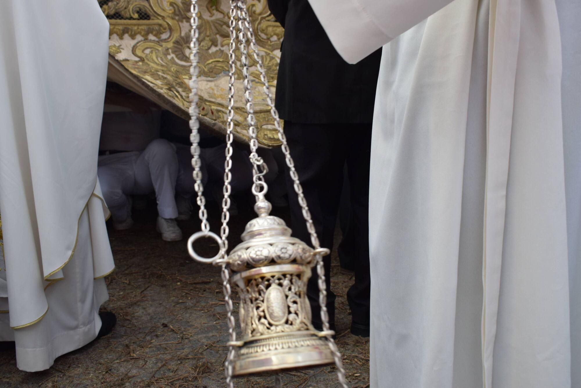 Costaleros bajo el paso de la Custodia descansan mientras el incensiario reparte aroma durante la procesión del Corpus de Sevilla
