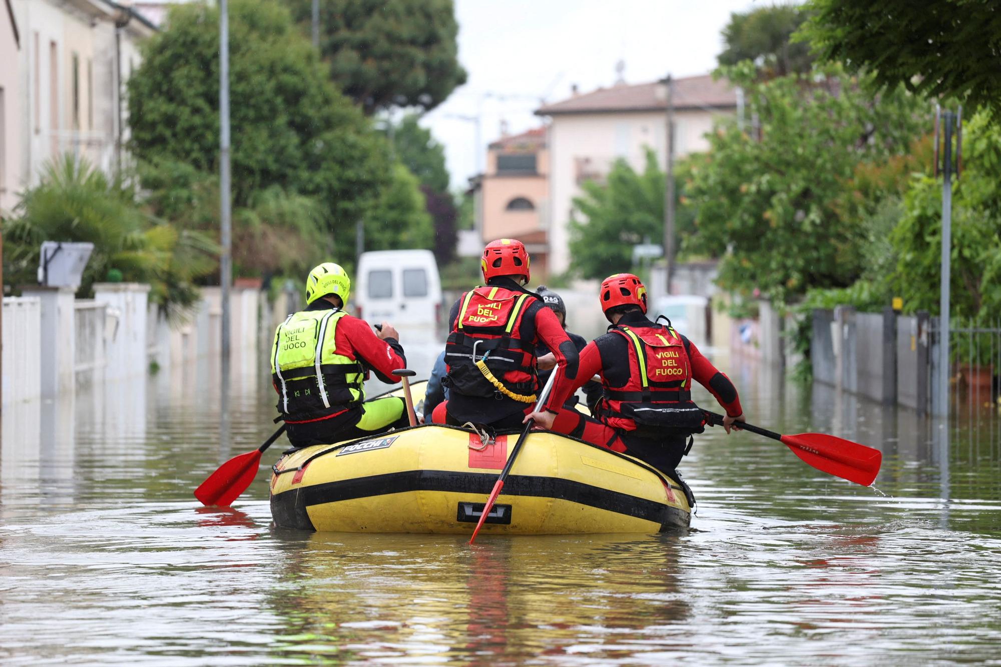 Bomberos llevan agua y comida a personas atrapadas en sus casas por las inundaciones en la region italiana de Emilia Romaña, este viernes.