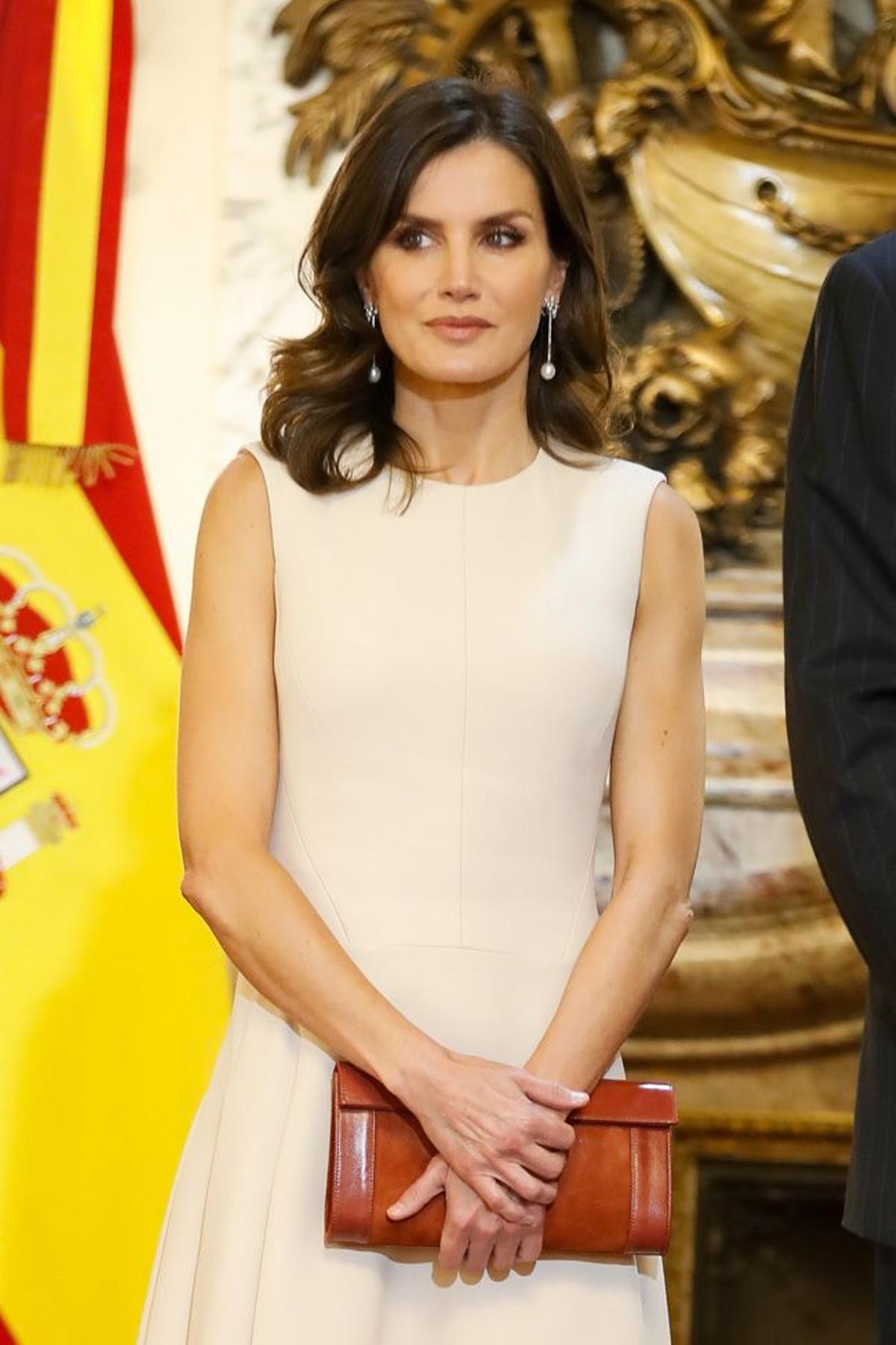 Detalle del look de Letizia Ortiz con vestido blanco sin mangas y zapatos y bolso en rojo de Magrit