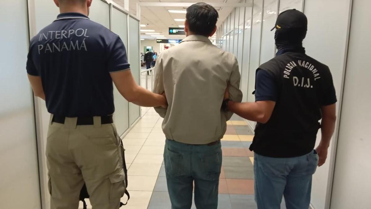 Los agentes de la Interpol Panamá conducen al detenido tras interceptarlo en el principal aeropuerto del país centroamericano