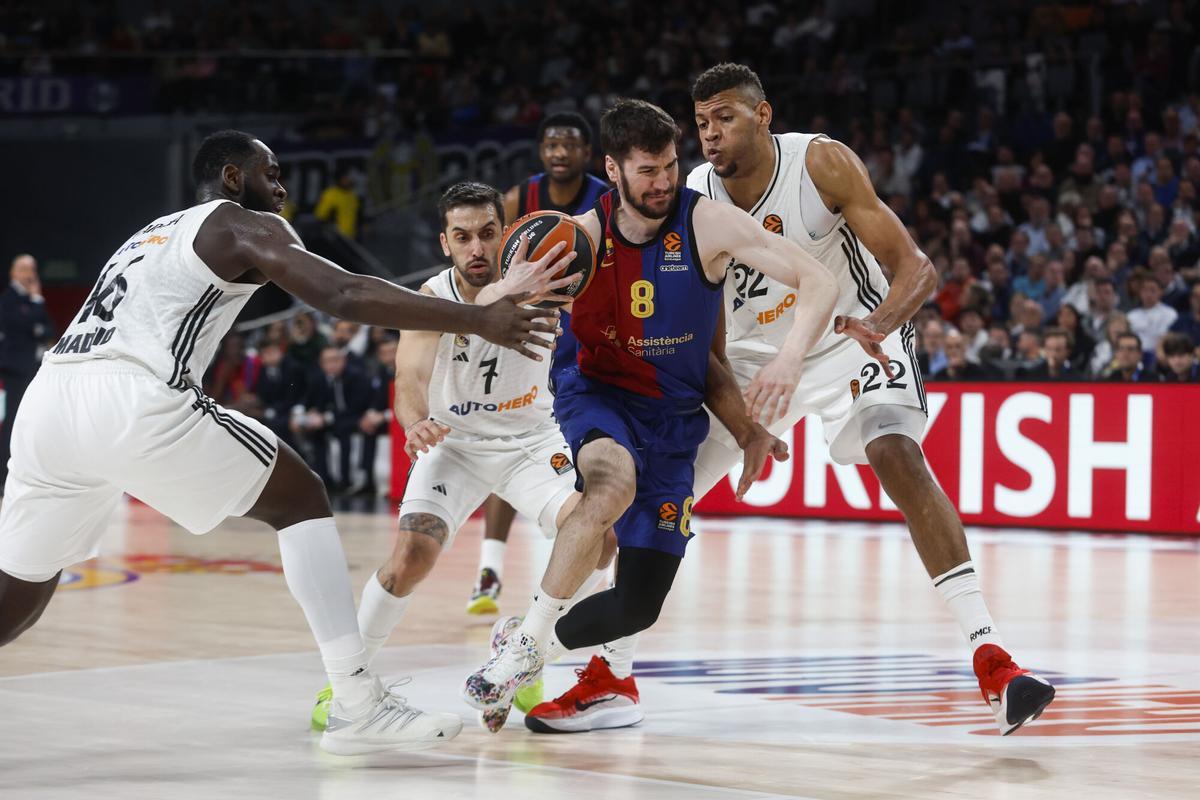 MADRID, 27/02/2025.- El base del Barça Darío Brizuela (c) entra a canasta entre Edy Tavares (d) y Usman Garuba (i), ambos del Real Madrid, durante el partido de la jornada 27 de la EuroLiga que Real Madrid y Barça disputan este jueves en el Movistar Arena, en Madrid. EFE/Juanjo Martín