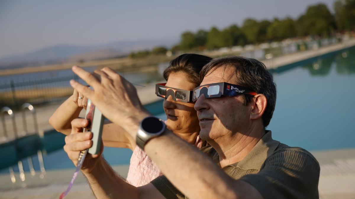 Dos personas contemplan el eclipse en el Festival del Eclipse de Buitrago del Lozoya