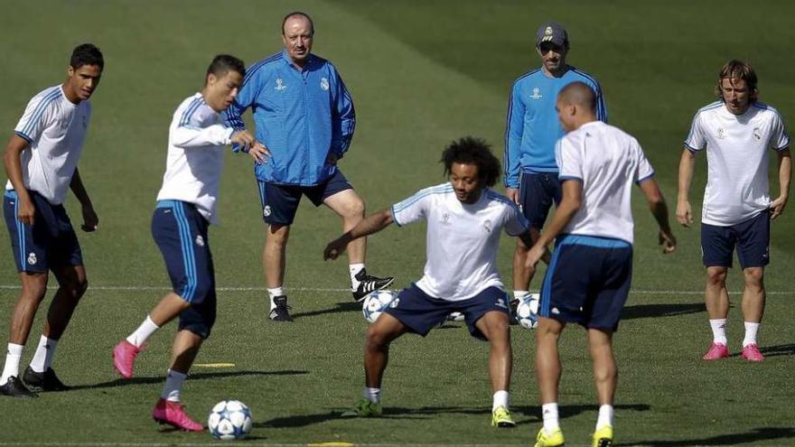 Cristiano Ronaldo toca el balón ante Marcelo, observado por Varane, Benítez, un ayudante de éste, Pepe y Modric, en el entrenamiento de ayer.