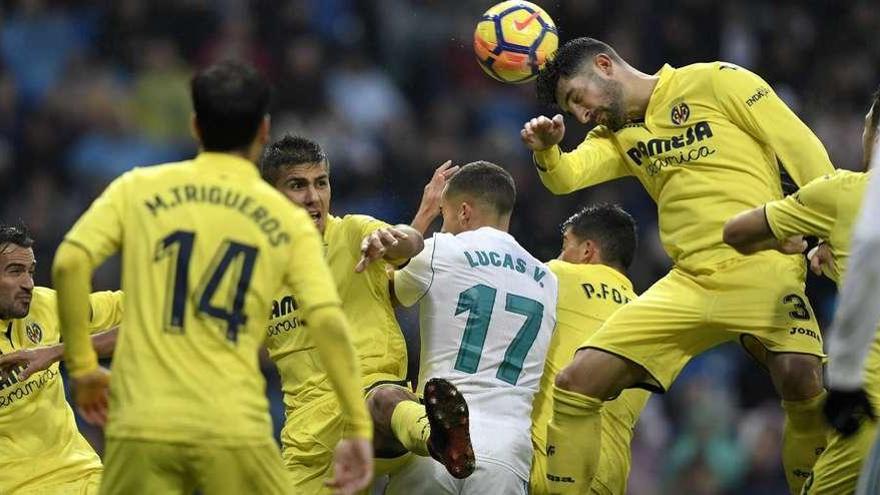 Álvaro cabecea entre varios jugadores durante el partido de ayer en el Santiago Bernabéu.