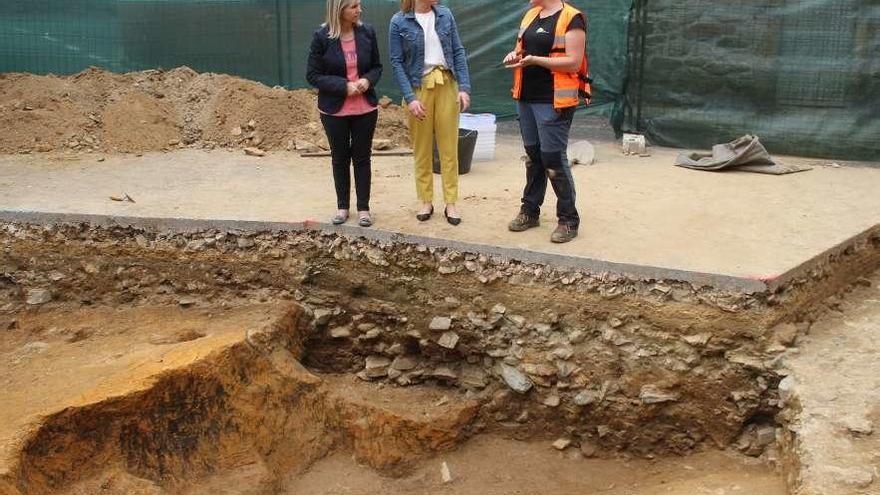 Pérez y Blanco conversan con la directora de la excavación, en la que se aprecian restos humanos.