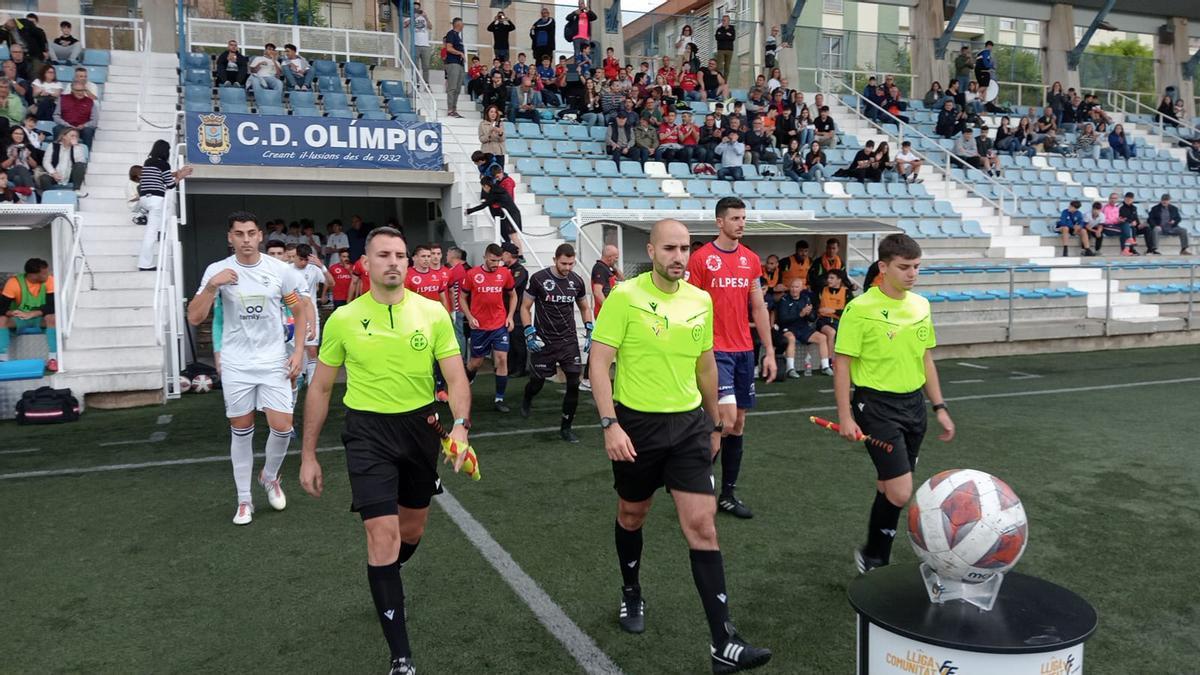 Salida al campo del trío arbitral y los equipos en el partido de Xàtiva