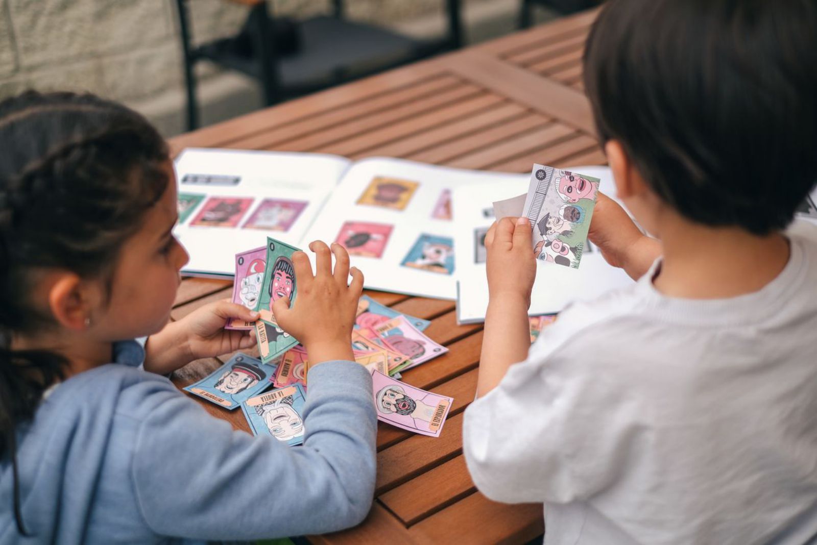 Dos niños de Puerto de Vega con los cromos y el álbum de los Cabezudos.