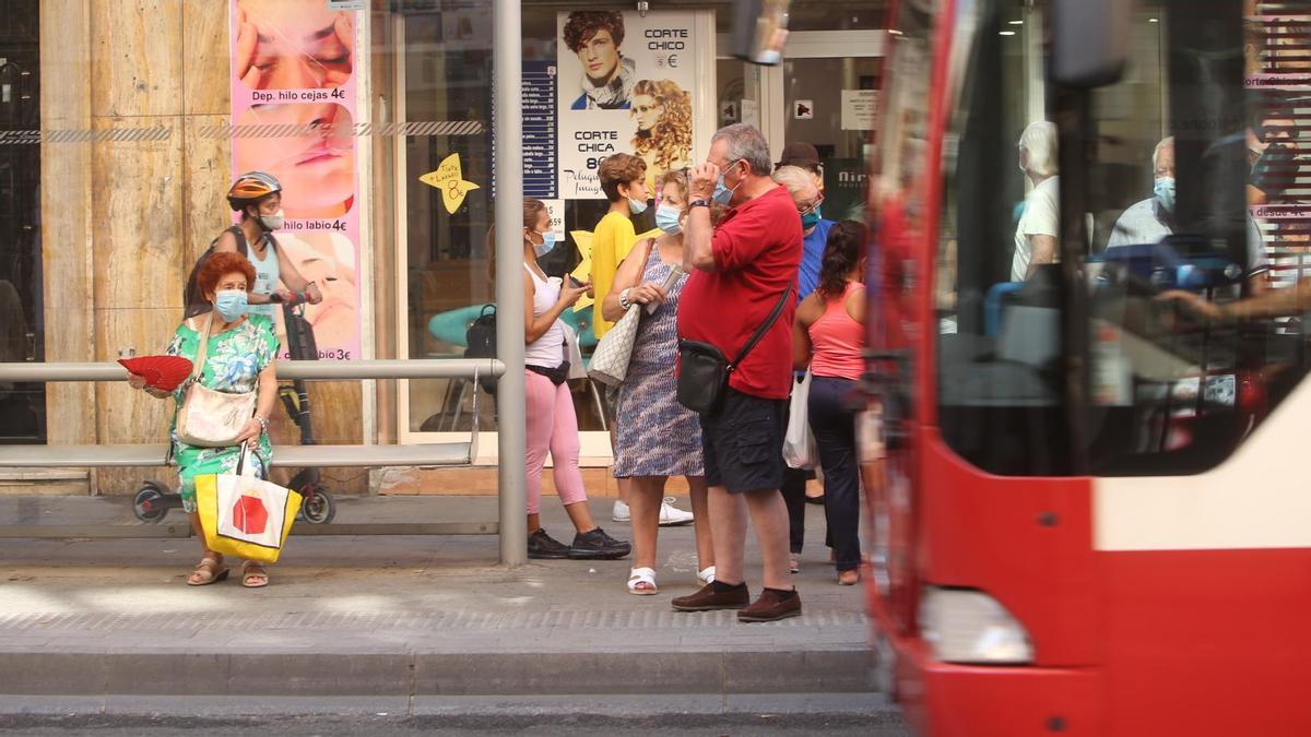 Viajeros esperan a un autobús, en Alicante