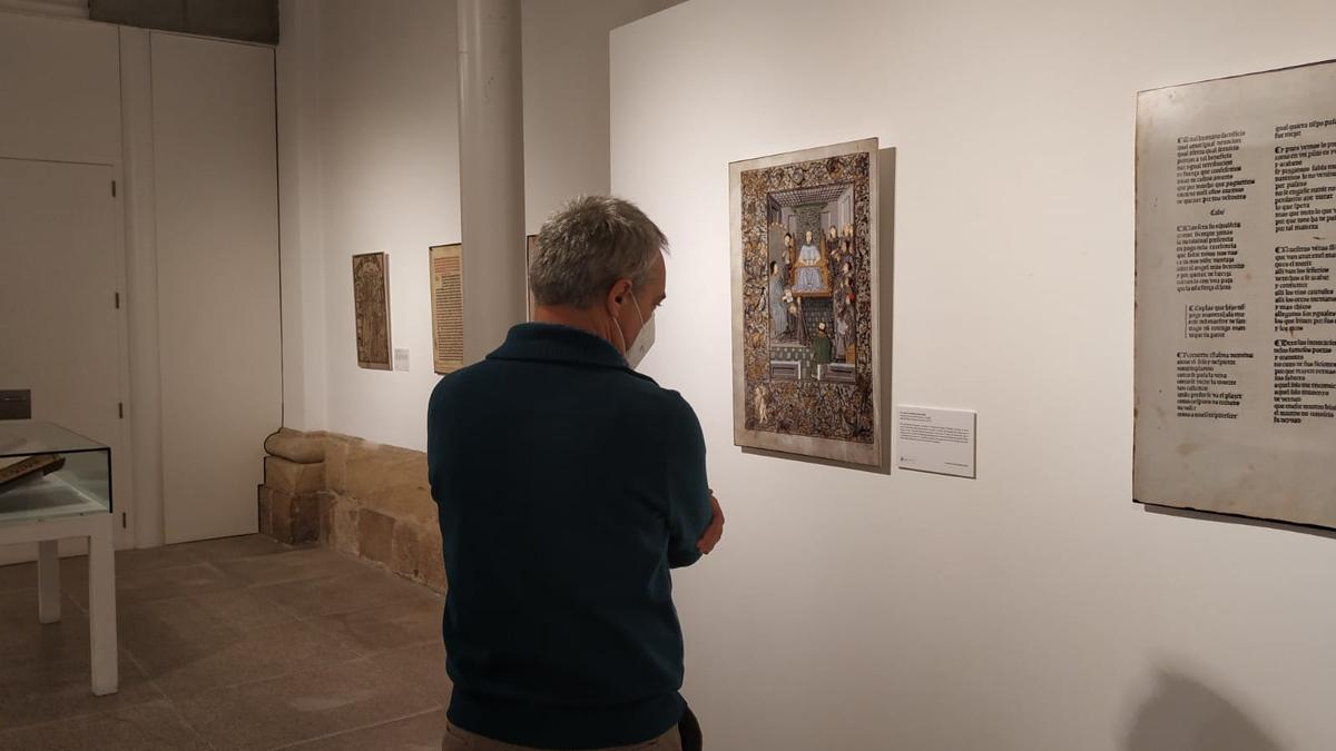 Un hombre contempla una de las imágenes de libros  antiguos exhibidas