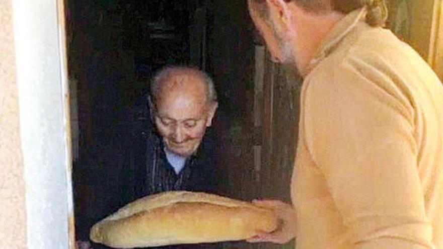 Horaci Botella entrega un pa a un avi que no el pot anar a comprar