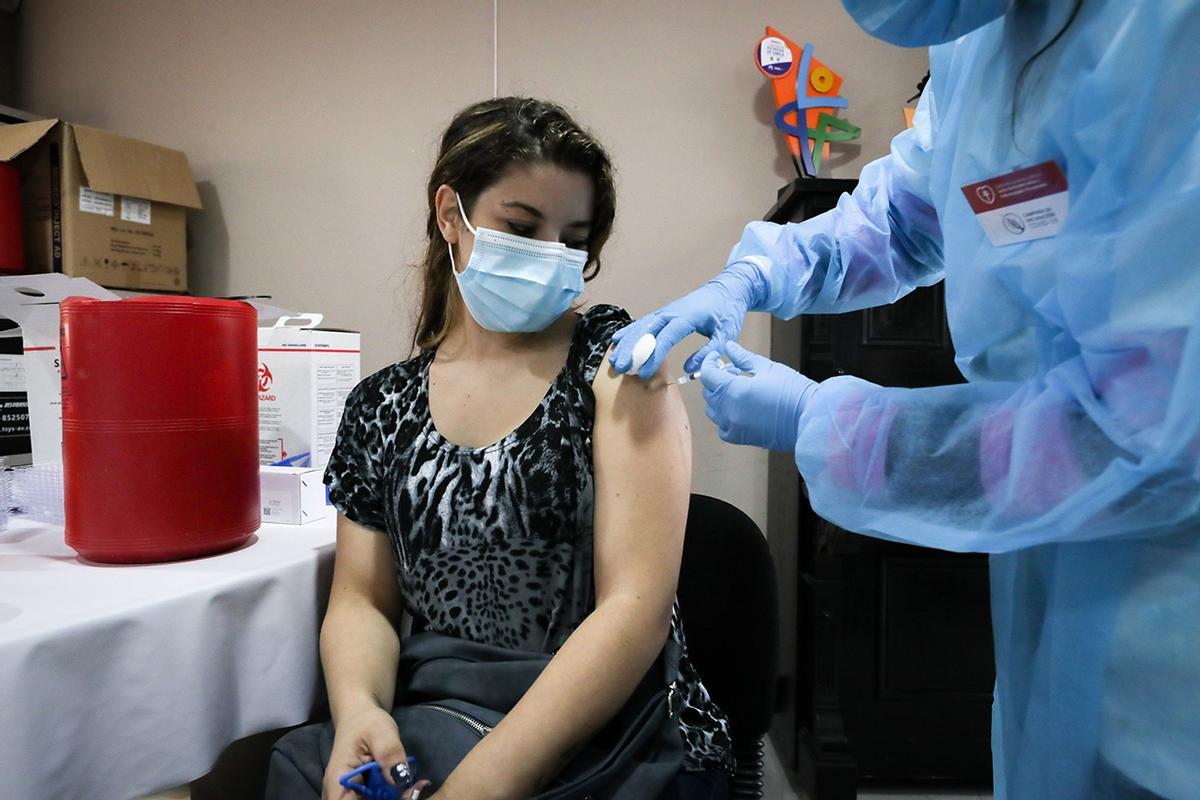 Una mujer recibe una vacuna contra la covid-19 el 31 de marzo de 2021 en el Hospital Público de Rivera, en Rivera (Uruguay). Una tierra que no sabe de fronteras, donde la línea imaginaria . Foto de Raúl Martínez (EFE)