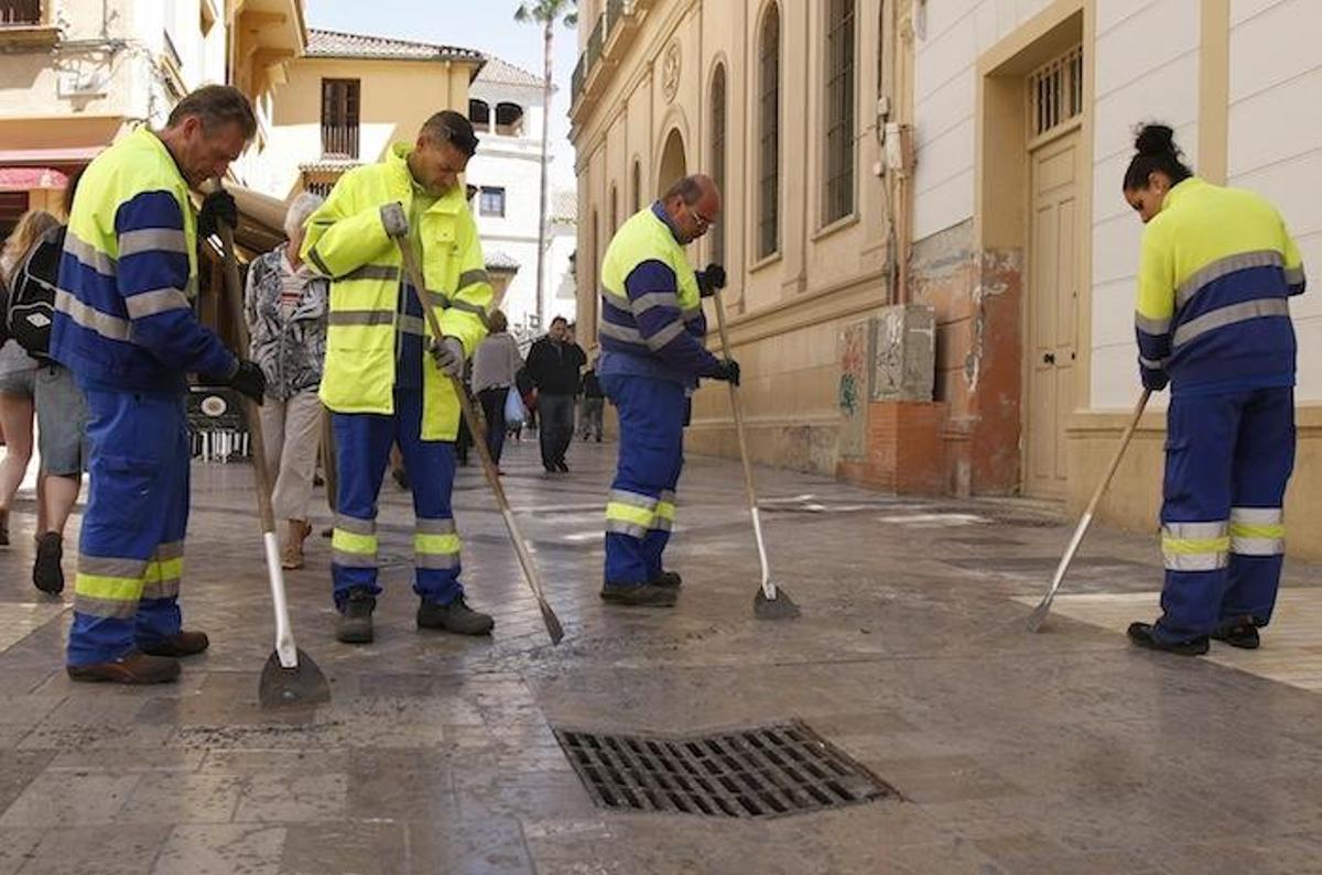 Varios operarios de Limasa retiran cera de una calle del Centro.