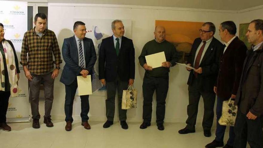 Por la izquierda, Concepción Velasco, concejala del PP; el artista Alberto Ámez; el director de la oficina de Caja Rural en Luarca, Belarmino Suárez; el jefe de zona de Caja Rural, José Ramón González; el concejal de Cultura, Gumersindo Cuervo; el alcalde de Valdés, Simón Guardado; el viceconsejero de Cultura, Vicente Domínguez, y el artista Rafael Rollón, durante el acto.