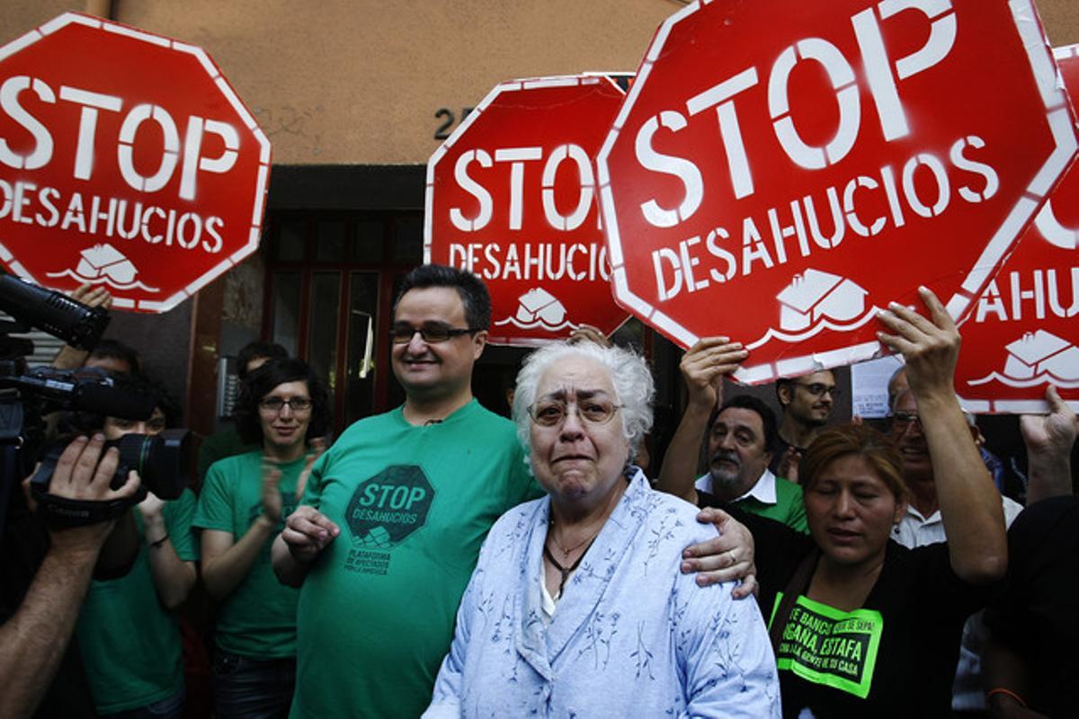 Maria Teresa Alsina i el seu fill, David Colmenero, envoltats per activistes del moviment contra els desnonaments, aquest matí a Badalona.