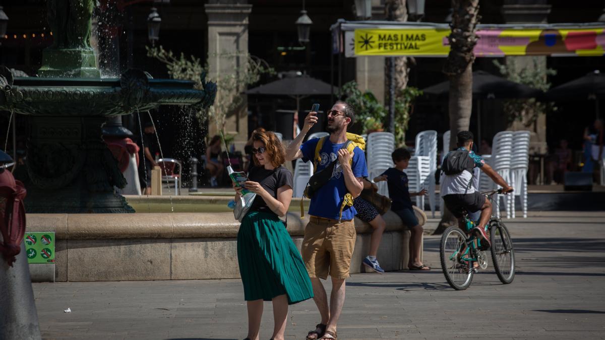 Dos turistas en la plaza Real de Barcelona.