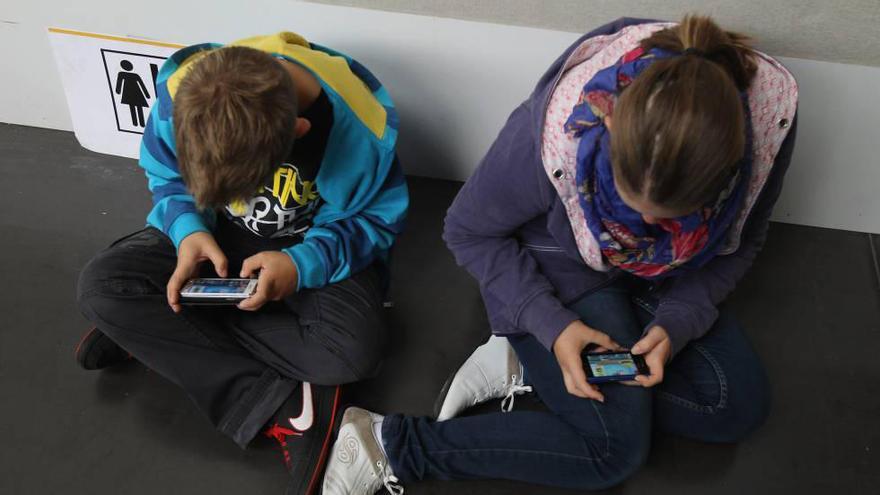 Dos niños con sus teléfonos inteligentes // FdV