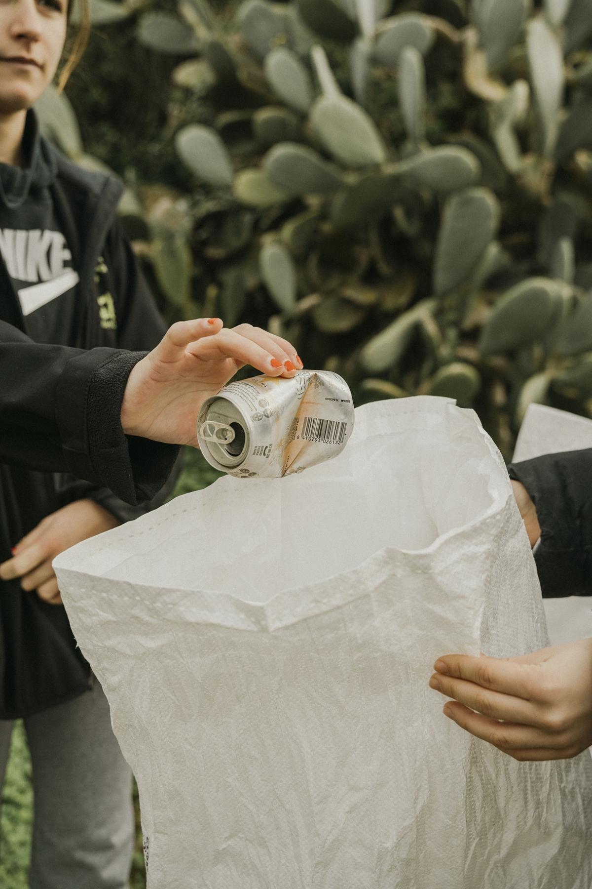 Alumnos recogiendo una lata del medio natural