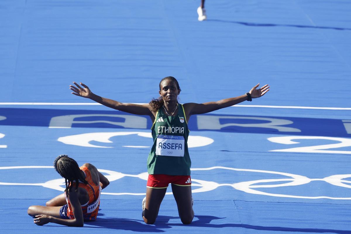 La atleta etíope Tigst Assefa tras cruzar la línea de meta para ganar la plata, junto a la holandesa Sifan Hassan, oro, en la prueba de maratón femenino de los Juegos Olímpicos de París 2024