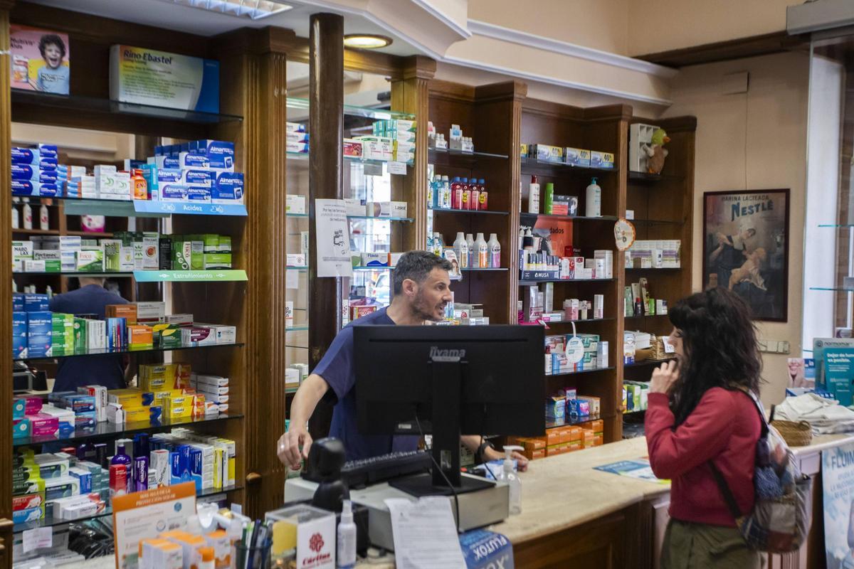 Un farmacéutico atiende a una paciente durante el apagón.