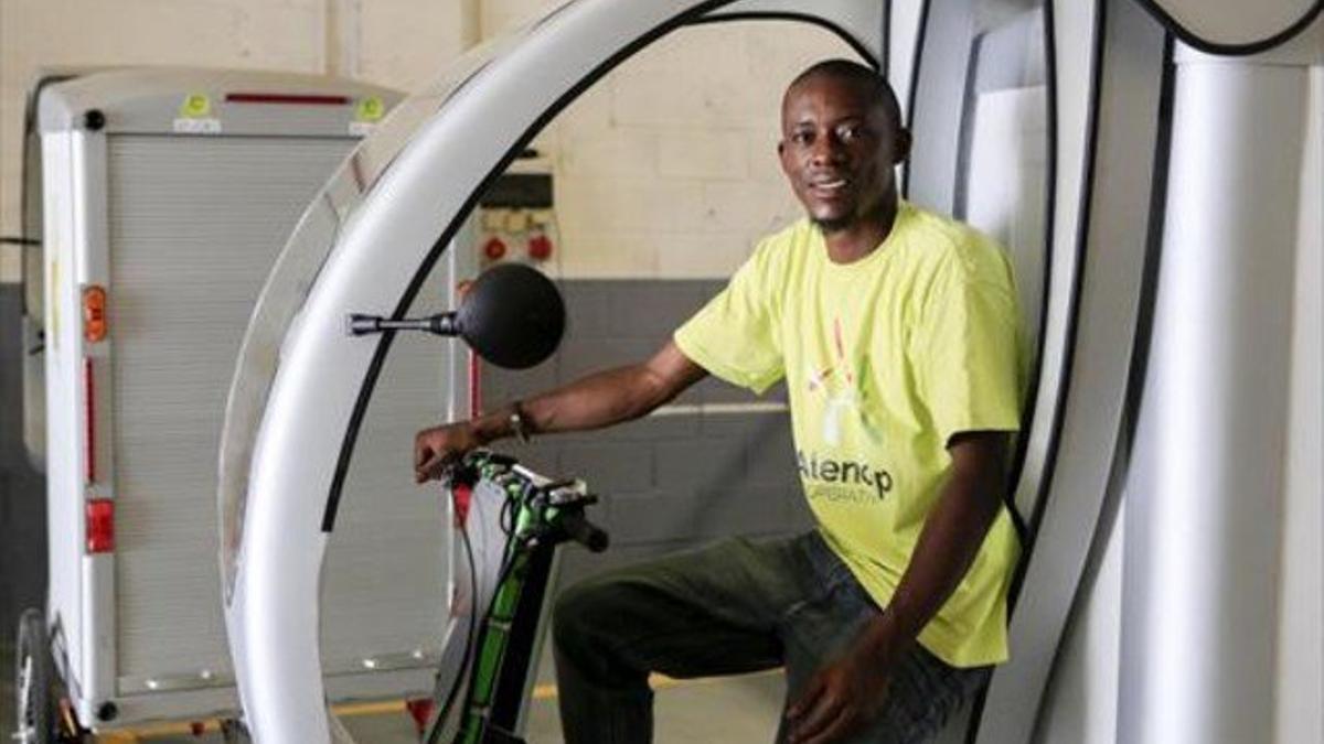 Joseph Amba, en la bicicleta eléctrica con la que recogen chatarra.