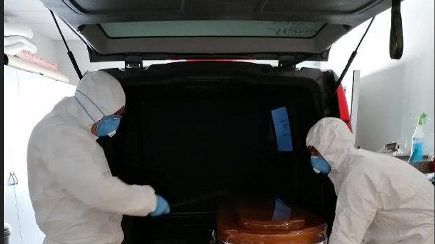 Dos funerarios de Cangas con sus trajes de protección para recoger un cadáver.// Fdv