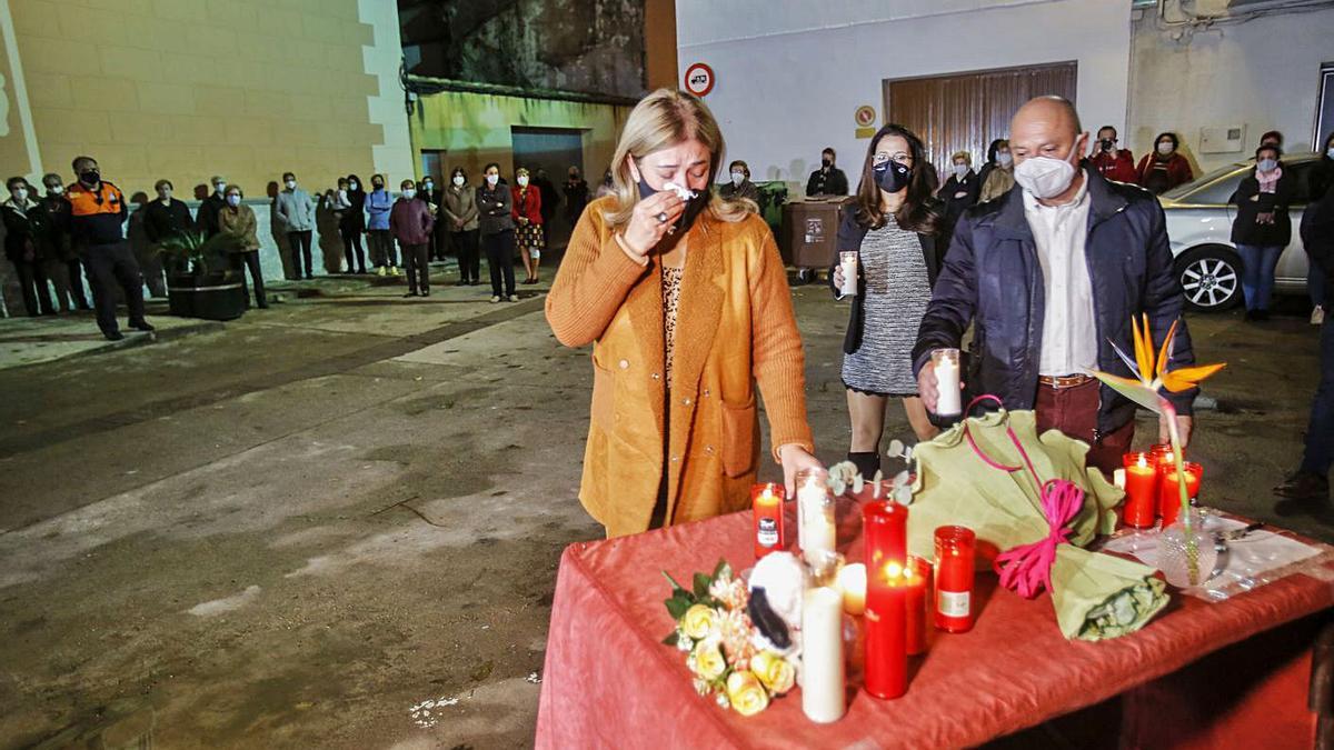 La madre de Marta hace una ofrenda ante el respetuoso silencio de los vecinos de Estivella. | EDUARDO RIPOLL