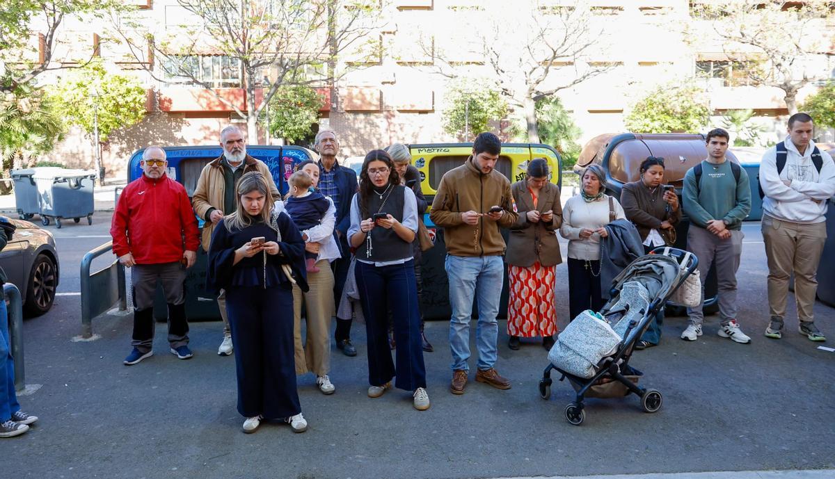 Rezos frente a la sala en la que se representa una misa negra.