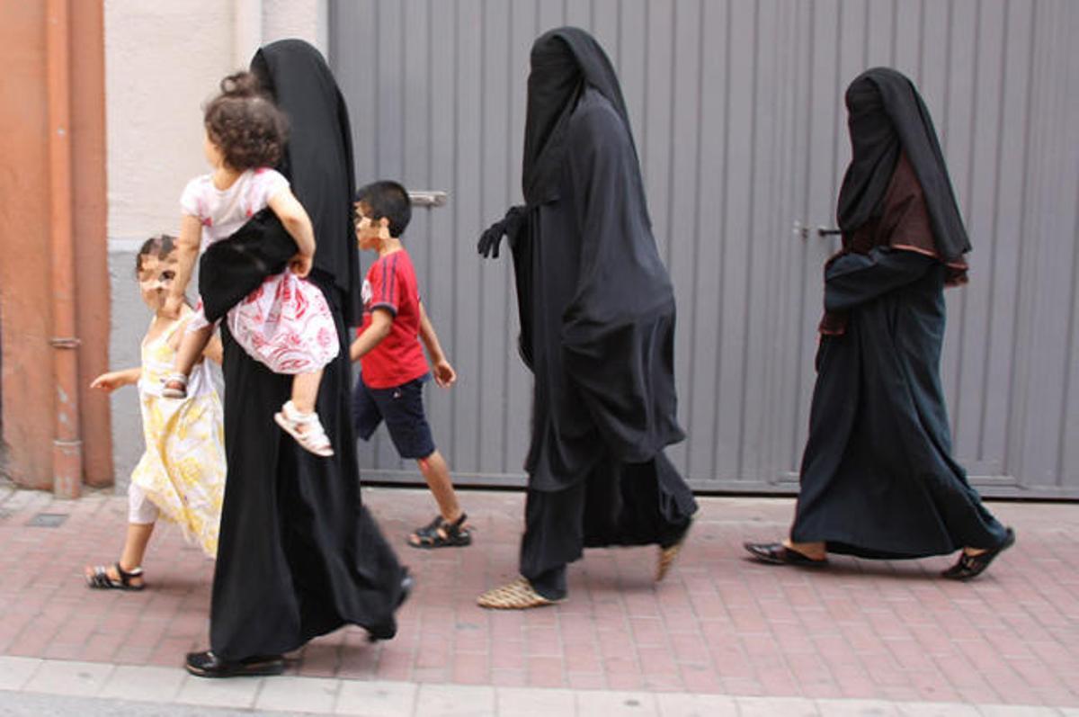 Dones amb burca passejant.