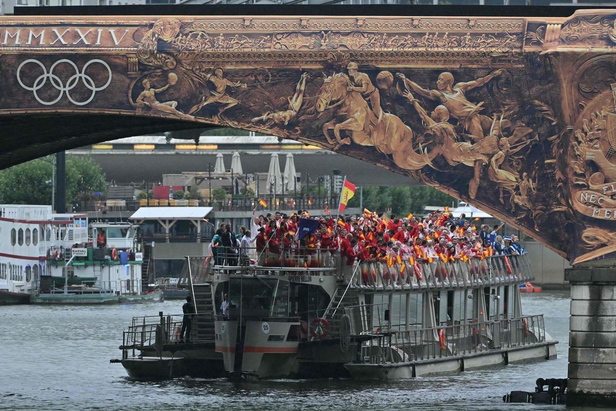 La delegación española ondeando las banderas mientras cruzan el puente Pont dAusterlitz a lo largo del río Sena durante la ceremonia de apertura de los Juegos Olímpicos de París 2024