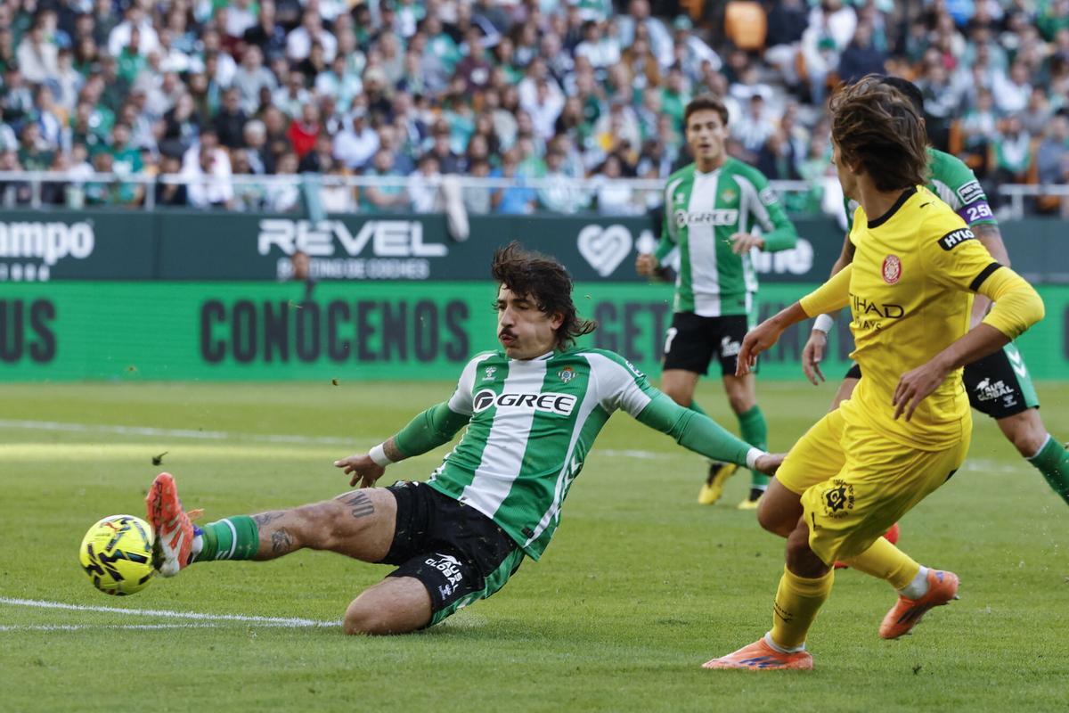 El defensa del Betis Héctor Bellerín (i) controla el balón en el partido ante el Girona de LaLiga de fútbol disputado este domingo en el estadio Benito Villamarín. EFE/ Julio Muñoz