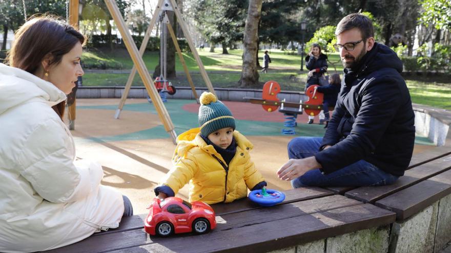 El pequeño Valentín, en el centro, jugando con su nuevo coche teledirigido junto a sus padres, Jennifer Marín y Román Piñeiro, ayer, en una zona de juegos del Campo San Francisco. | F. Rodríguez