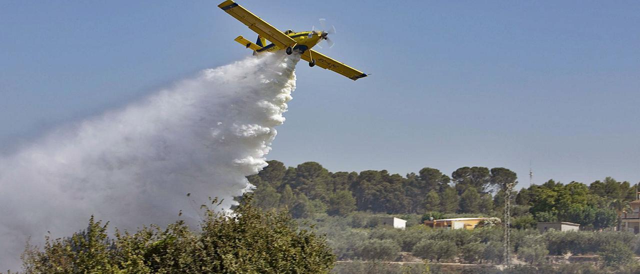 Una avioneta descarga agua sobre un incendio reciente producido en una localidad de la Vall d’Albaida. | PERALES IBORRA