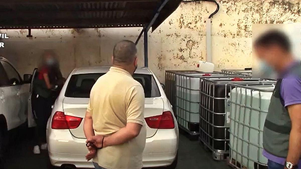 El detenido, ante el BMW 318 blanco en el que subió a Florina, ayer, en su empresa. | GUARDIA CIVIL