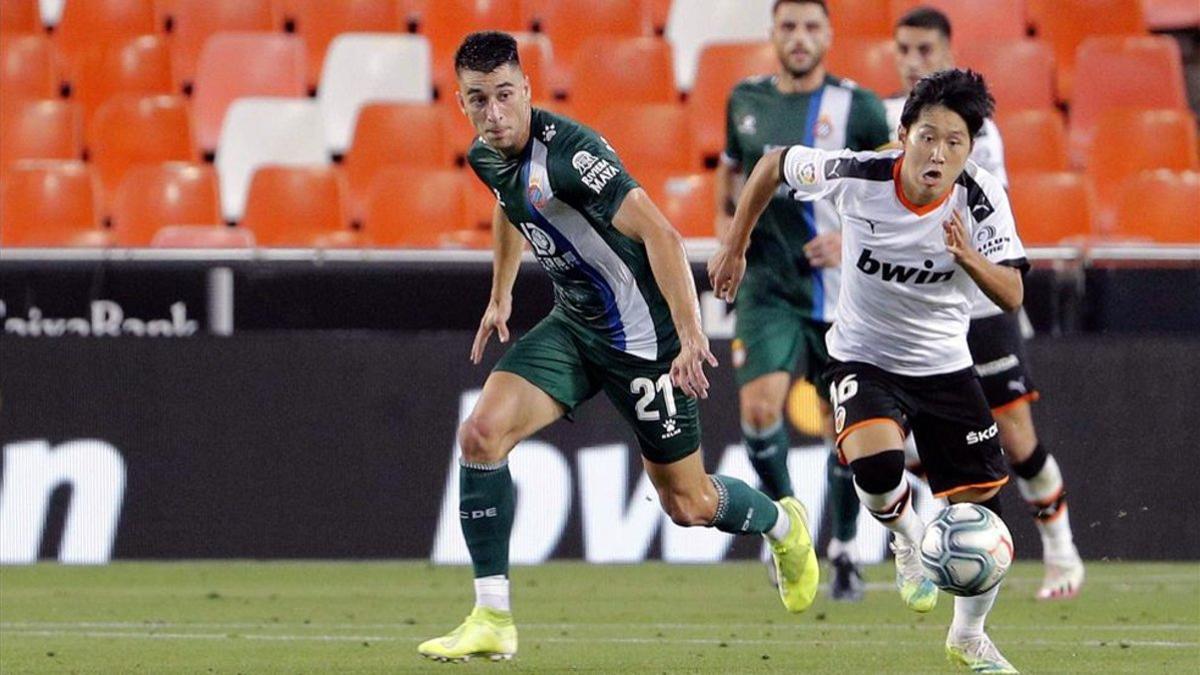 Marc Roca persigue a Kang-in Lee en el último duelo del Espanyol ante el Valencia.