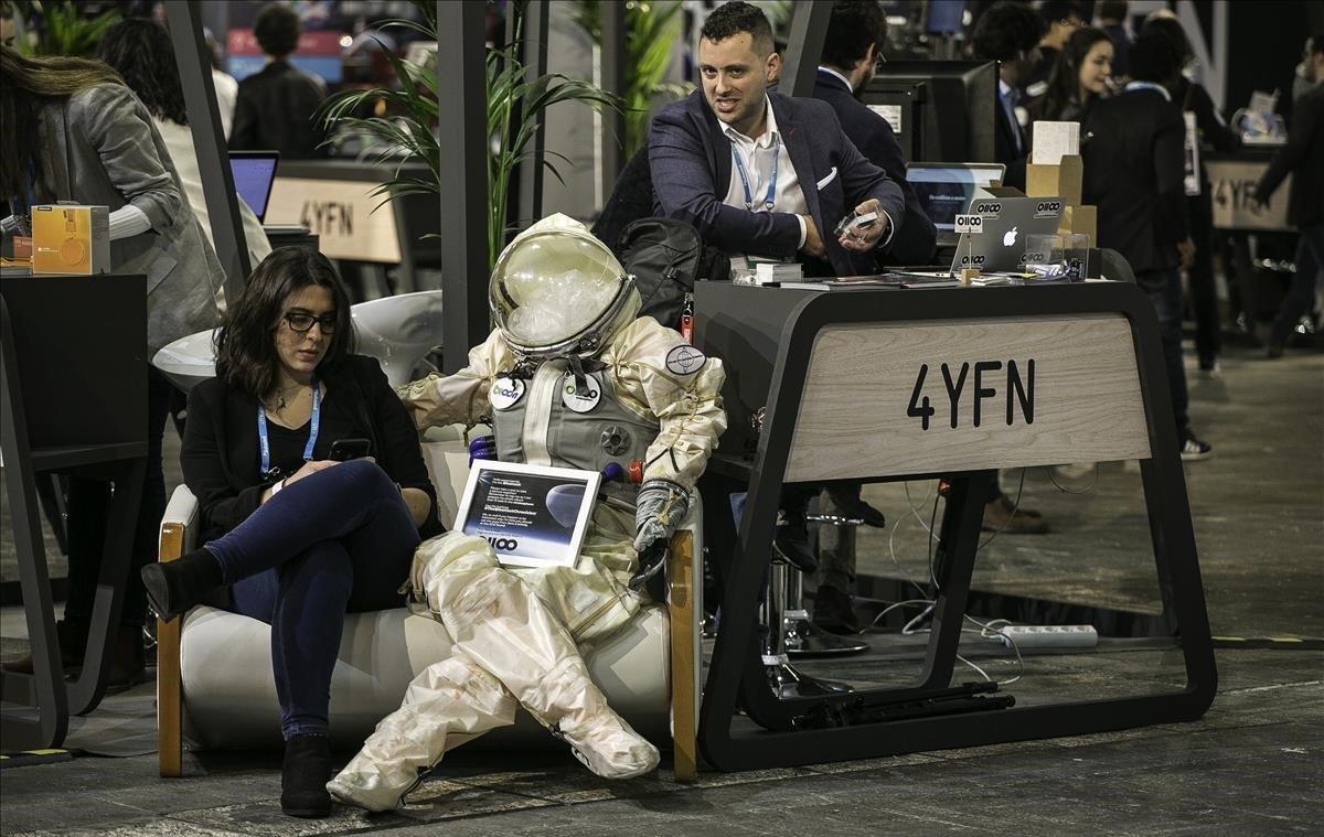 Un robot cómodamente sentado junto a una visitante del salón 4YFN en el Mobile World Congress.