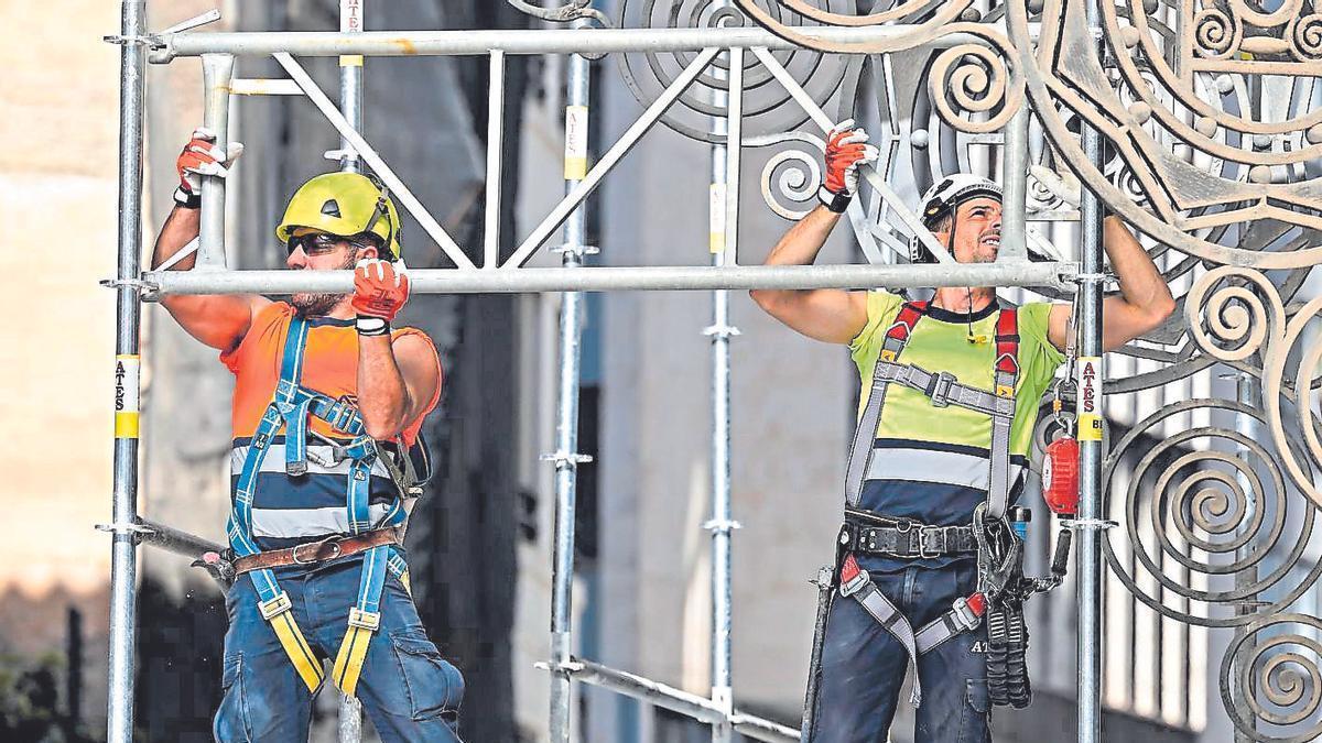 Trabajadores de la construcción montan un andamio.