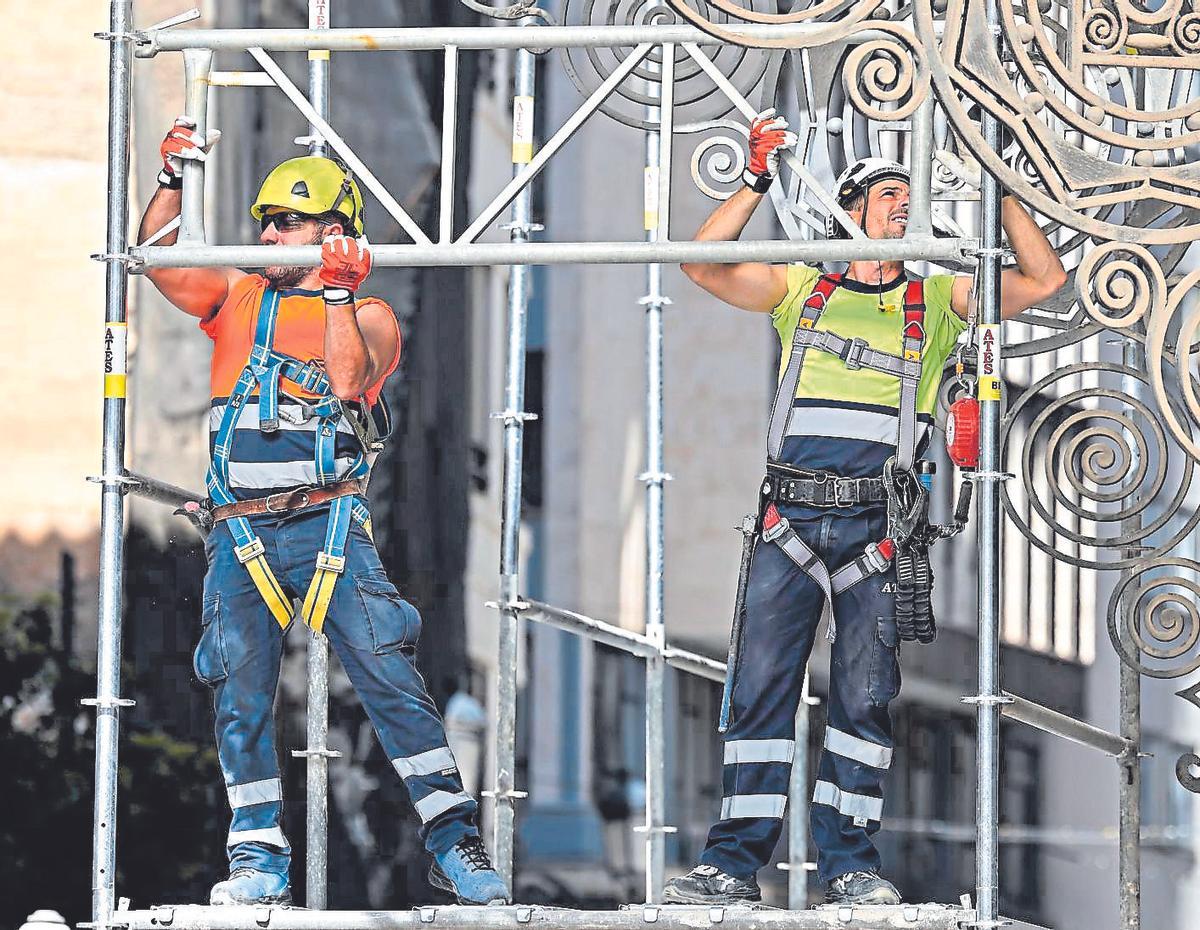 Trabajadores de la construcción montan un andamio.