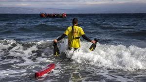 Un socorrista de Activa Open Arms sale al mar para ayudar a refugiados, frente a las costas de Lesbos.