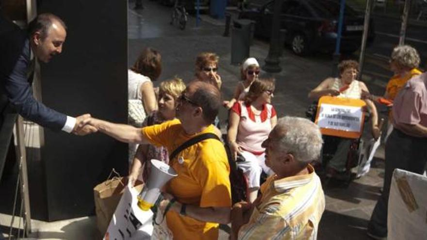 El conseller de Justicia y Bienestar Social se acerca a los dependientes concentrados ayer en Alicante.