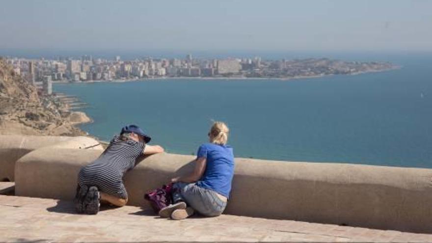 Dos turistas observan la bahía de Alicante desde el castillo de Santa Bárbara.