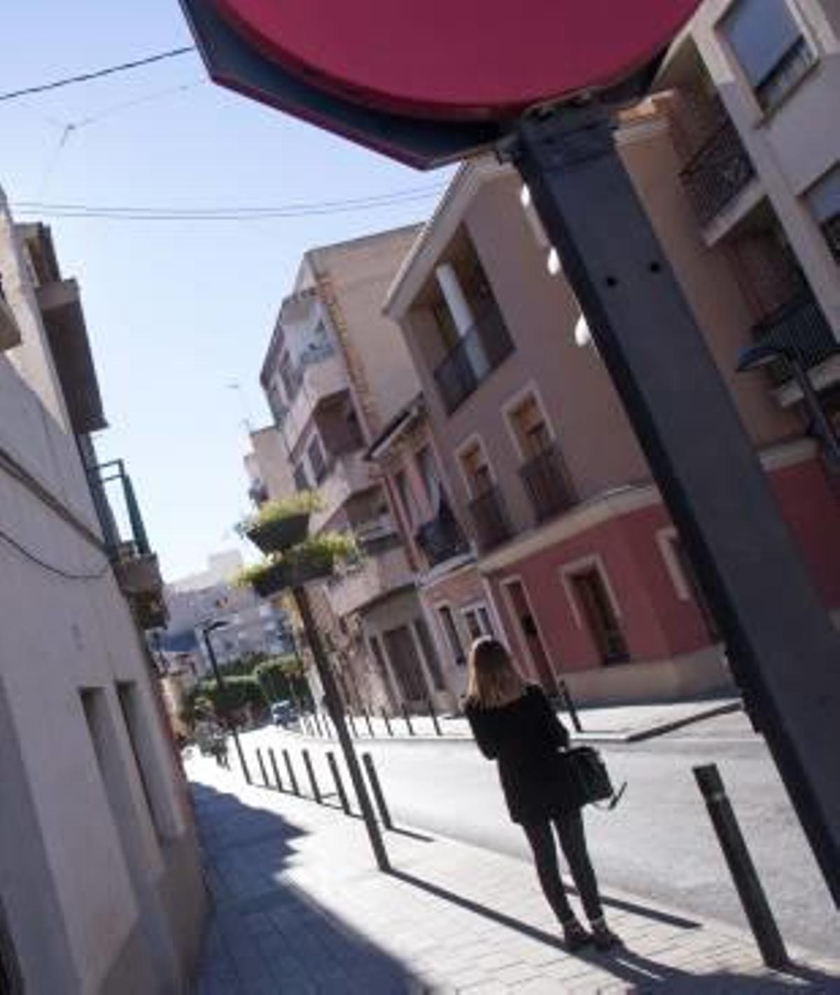 Una mujer camina por la calle Comandante Seva.