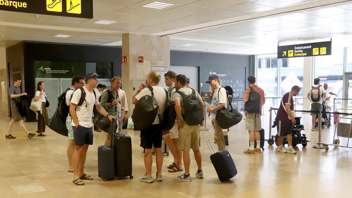 Un grup de turistes espera per fer el control de seguretat a l'aeroport de Girona