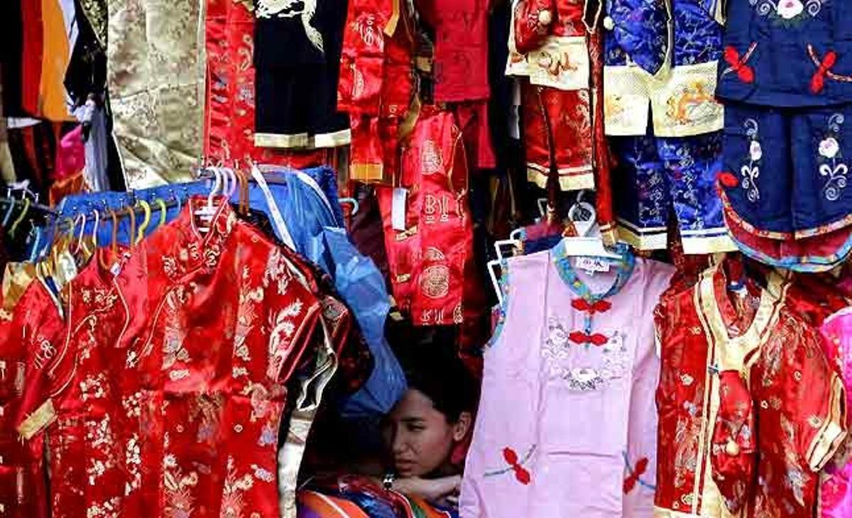 Una venedora tailandesa espera l’arribada de clients a la seva botiga a Bangkok (Tailàndia).