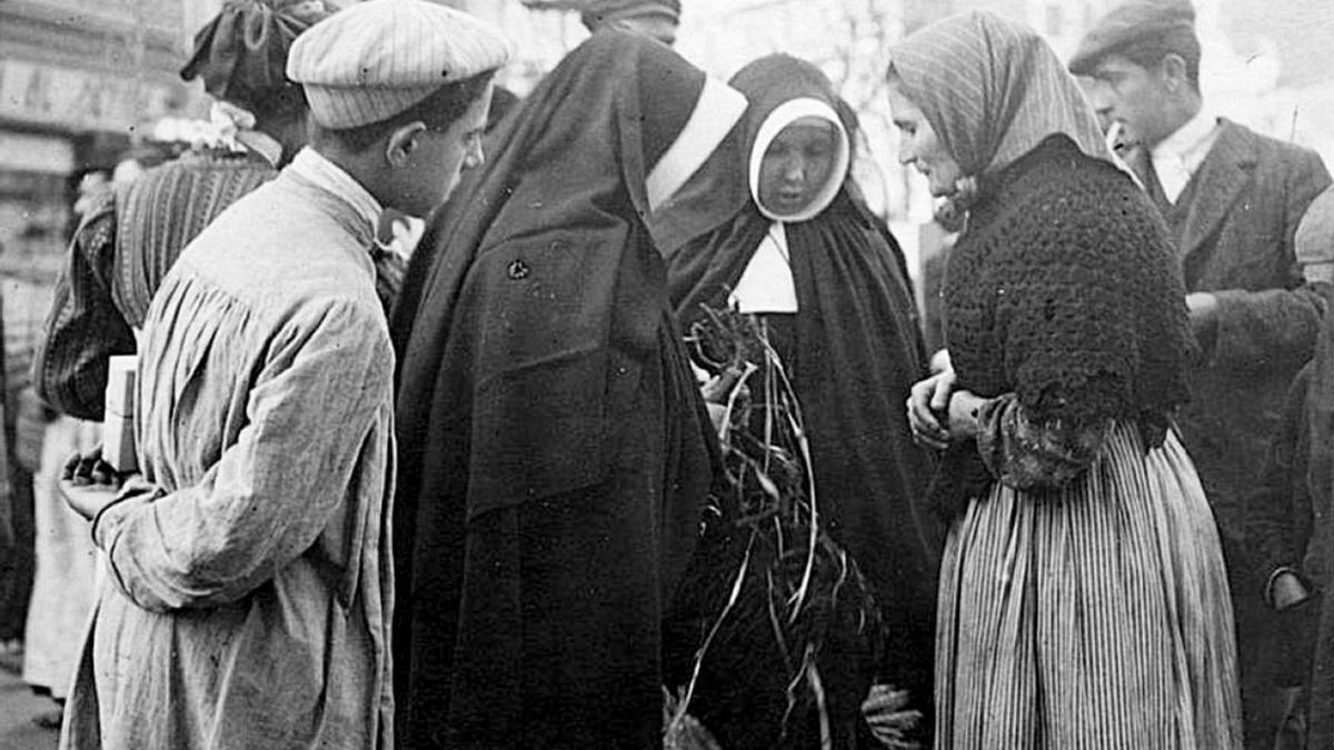 Un grupo de religiosas asisten a personas en la calle durante el siglo pasado.