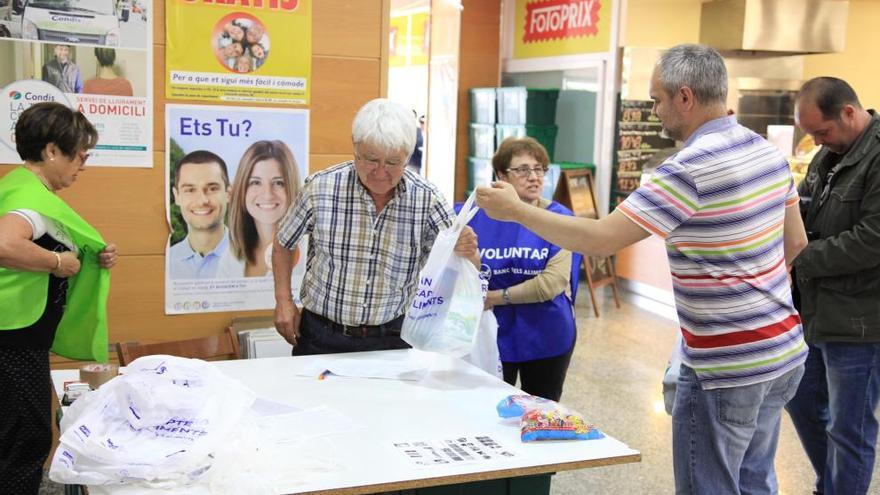 Voluntaris recollint aliments en un supermercat de Roses.