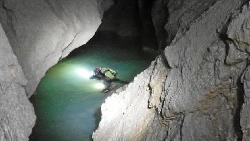 Wasser zwischen nackten Felsen: Ein Höhlenforscher durchschwimmt den See.