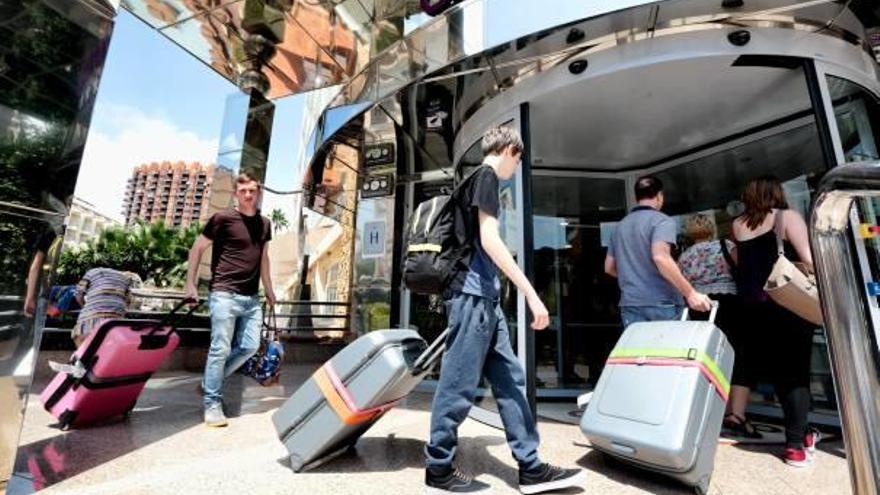 Un grupo de turistas cargados de maletas entra a un hotel en Benidorm en una imagen de archivo.